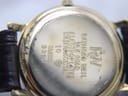 Close-up of the stainless steel case back with engravings: Raymond Weil, 18K gold electroplated, water resistant, Swiss, 9920. Visible wear to plating.