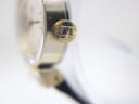 Extreme close-up of the textured gold crown, distinctly featuring the Tissot 'T' emblem.