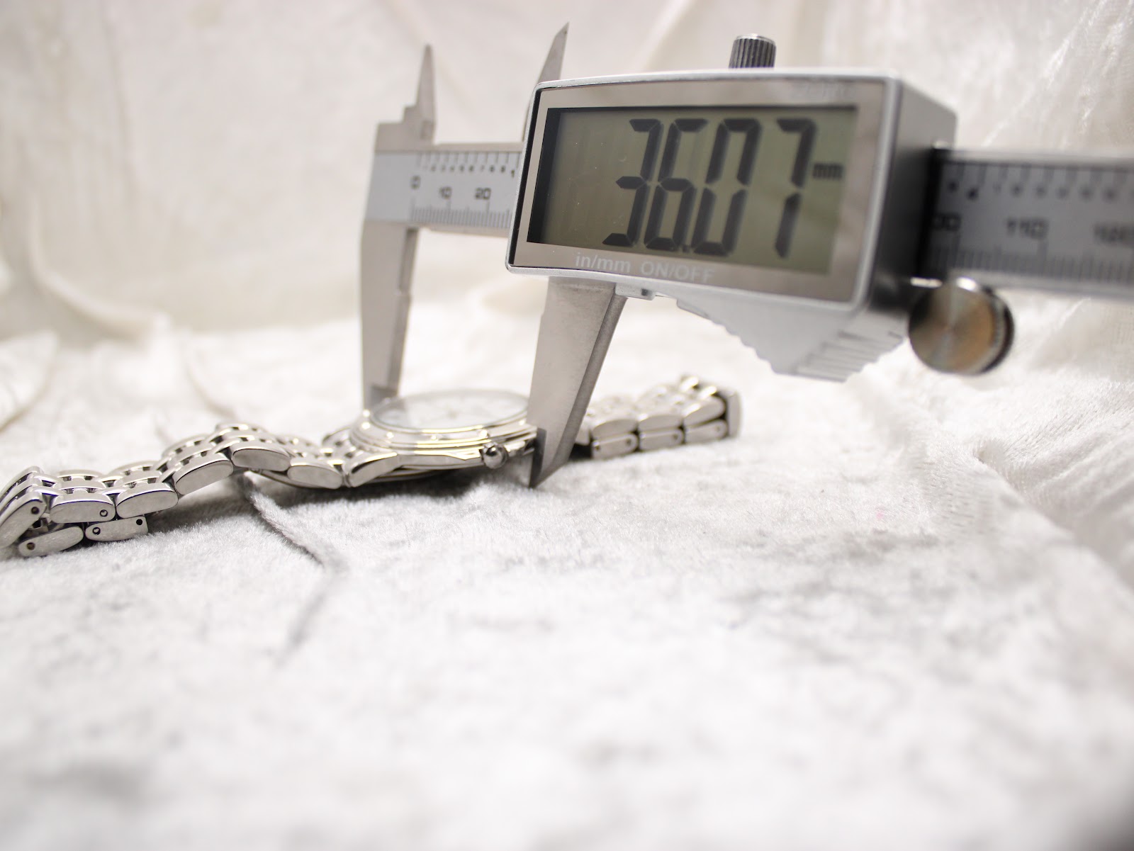 Digital caliper measuring the case diameter of the Raymond Weil Tango, displaying 36.07 mm.