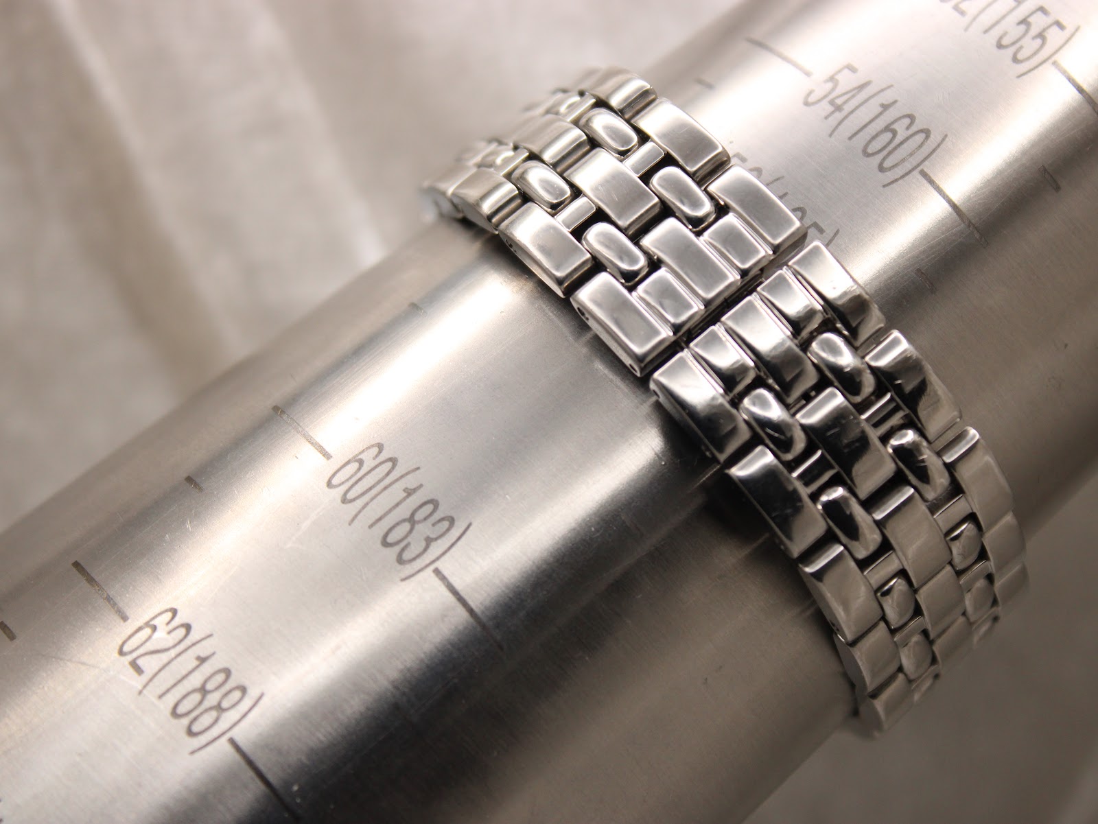 Close-up of the stainless steel bracelet wrapped around a wrist sizing mandrel, indicating a fit of approximately 175mm to 180mm.