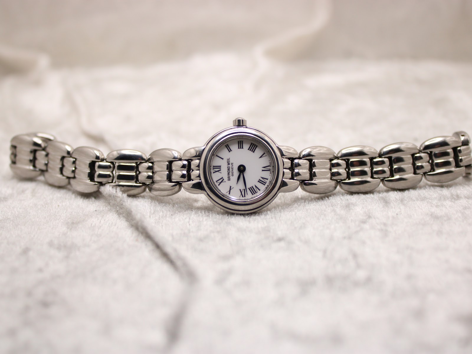 Full length view of the Raymond Weil Genève 5880 watch with its stainless steel bracelet laid flat, featuring the dial and bracelet design.