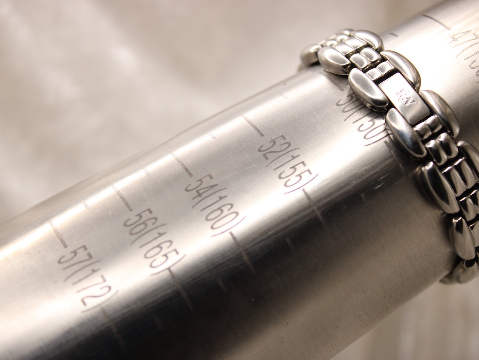 Close-up of the watch bracelet wrapped around a wrist sizing gauge, indicating a maximum wrist circumference of 150mm (15cm).