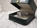 The Raymond Weil Genève 5880 watch displayed inside an open green presentation box, resting on a white cushion.