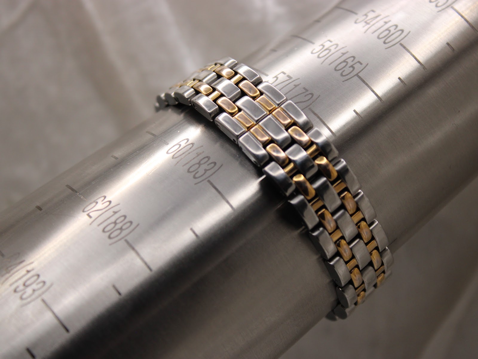 Close-up of the Raymond Weil two-tone stainless steel bracelet wrapped around a wrist sizing gauge, indicating a maximum wrist fit of approximately 175mm.