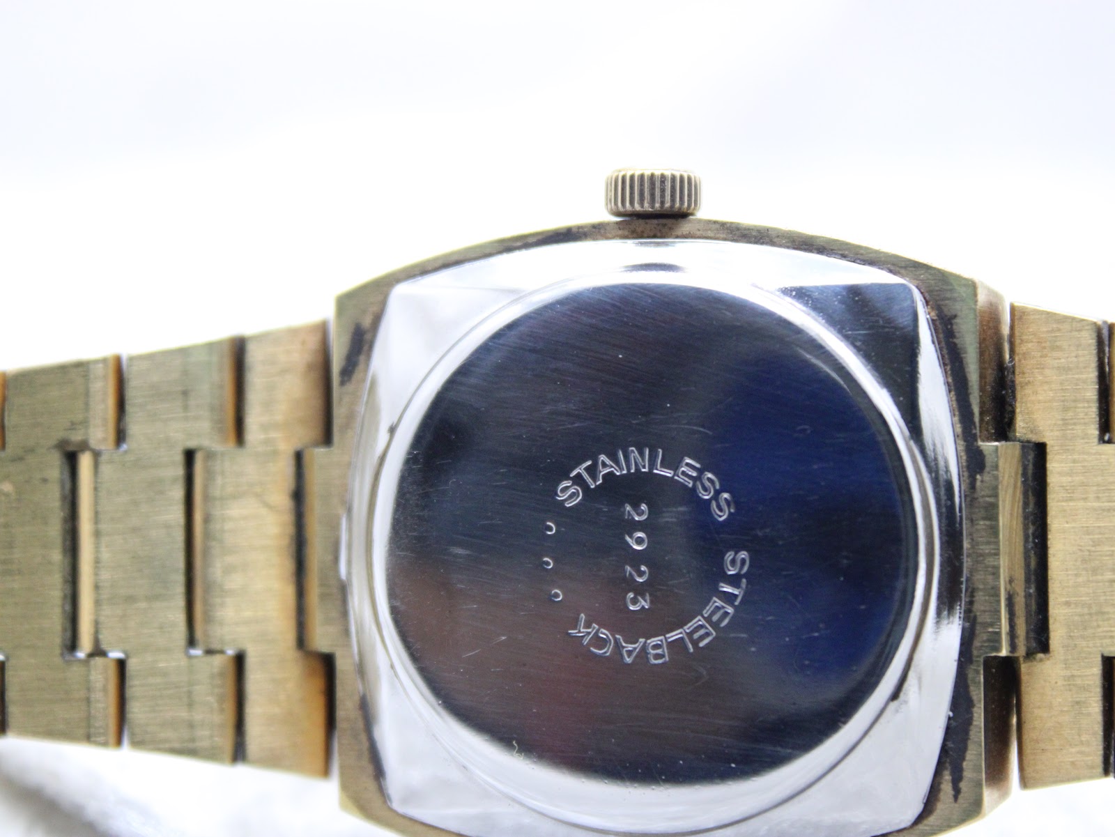Close-up of the watch's stainless steel case back with 'STAINLESS STEELBACK' and a serial number engraved.