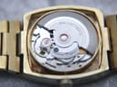 Close-up internal view of the Swiss automatic movement inside the Talis watch, showing the rotor and '25 JEWELS SWISS MADE' engraving.