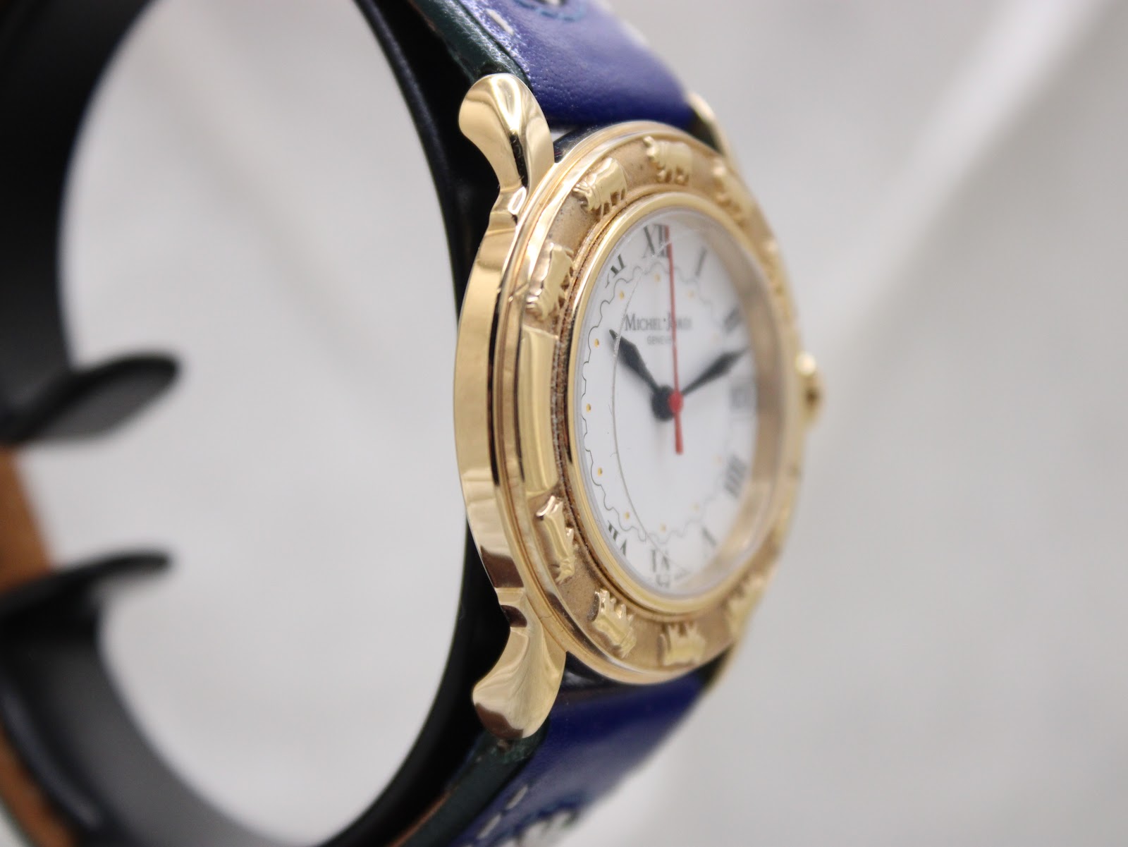 Another side view of the Michel Jordi Genève watch case, showcasing the sculpted lugs and decorative bezel.