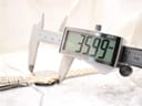 Digital caliper measuring the watch case diameter at 35.99 mm, highlighting the two-tone bezel.