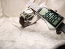 Digital caliper measuring the case diameter of the Lotus 15509 watch, showing a precise reading of 36.08mm on the display.