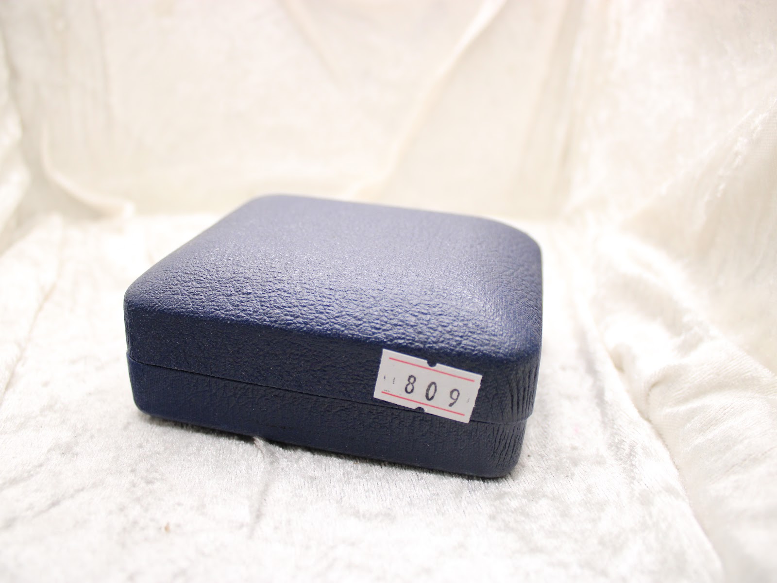 Exterior view of the closed generic blue presentation box, with a white sticker displaying the number "809".