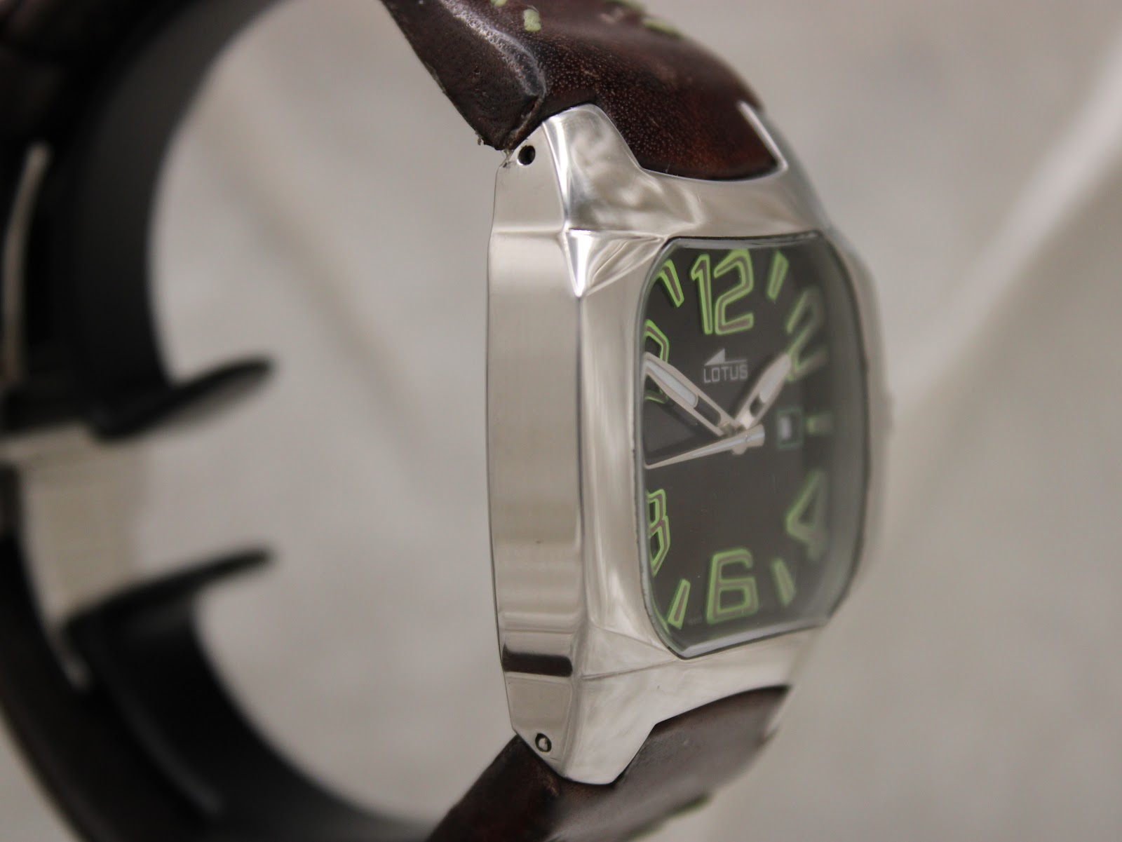 Side view of the Lotus 15509 stainless steel case from the left, showcasing the sleek, polished finish of the cushion-shaped watch case.
