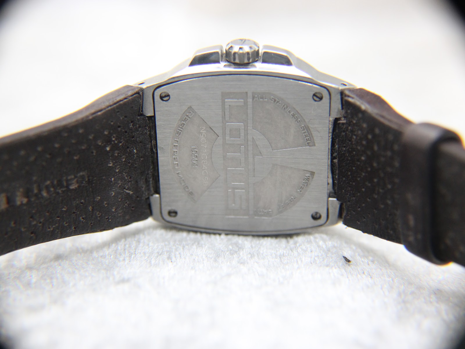 Rear view of the Lotus 15509 watch, displaying the stainless steel case back and the full brown leather strap with contrast stitching.