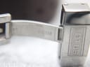 Close-up of the interior of the open Lotus branded deployant clasp, made of stainless steel.