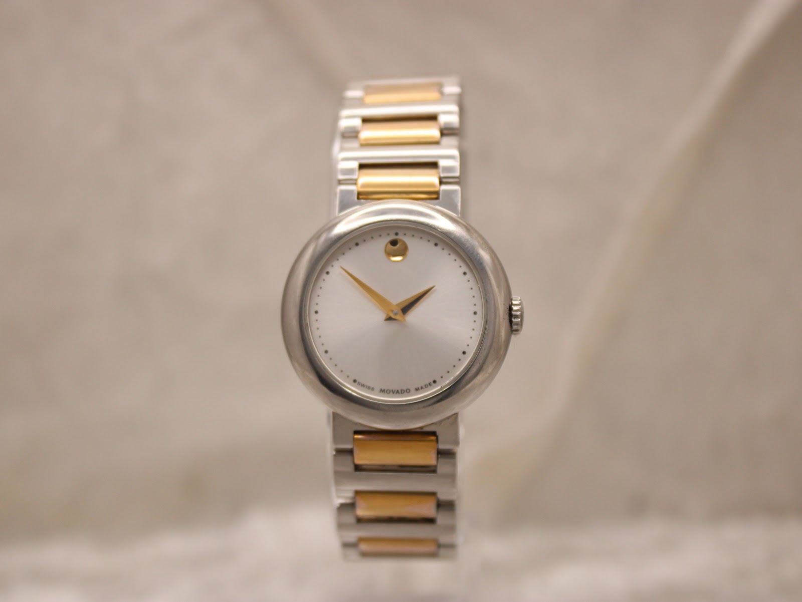 Front view of Movado Concerto watch, showcasing the iconic gold dot at 12 o'clock and minute markers.
