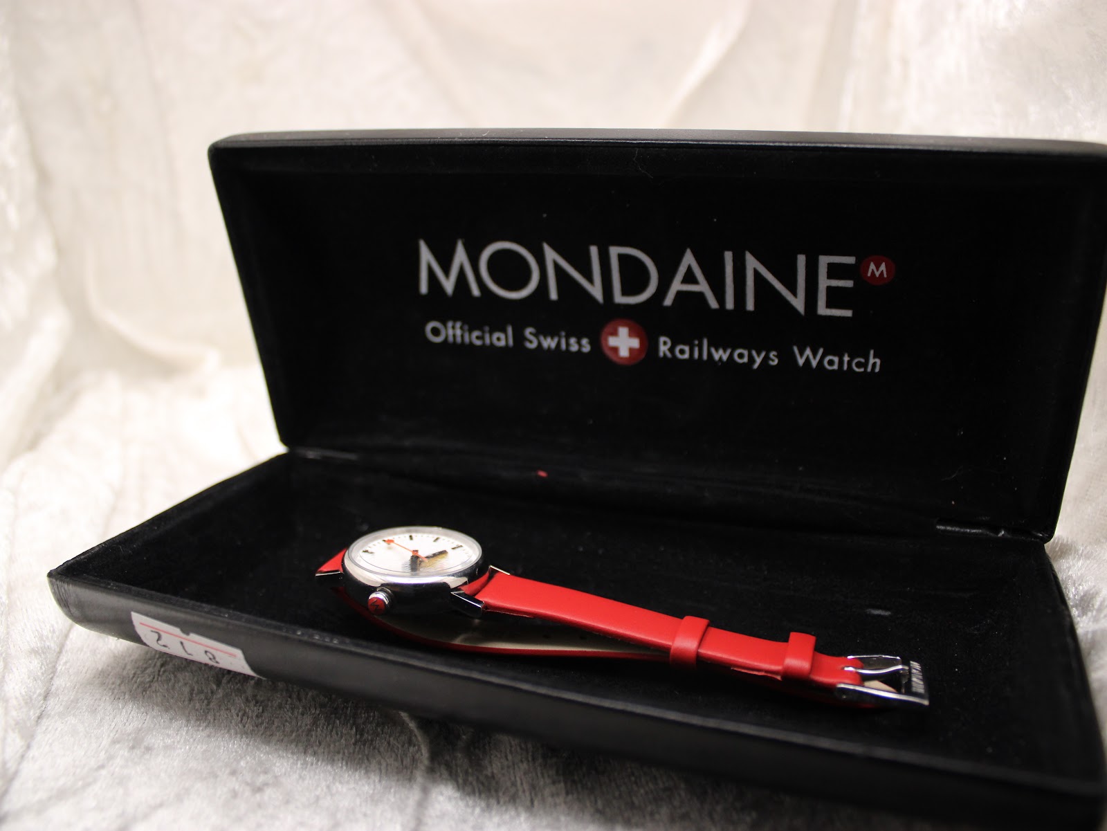 The Mondaine SBB CFF FFS watch presented in its open, black Mondaine branded box.