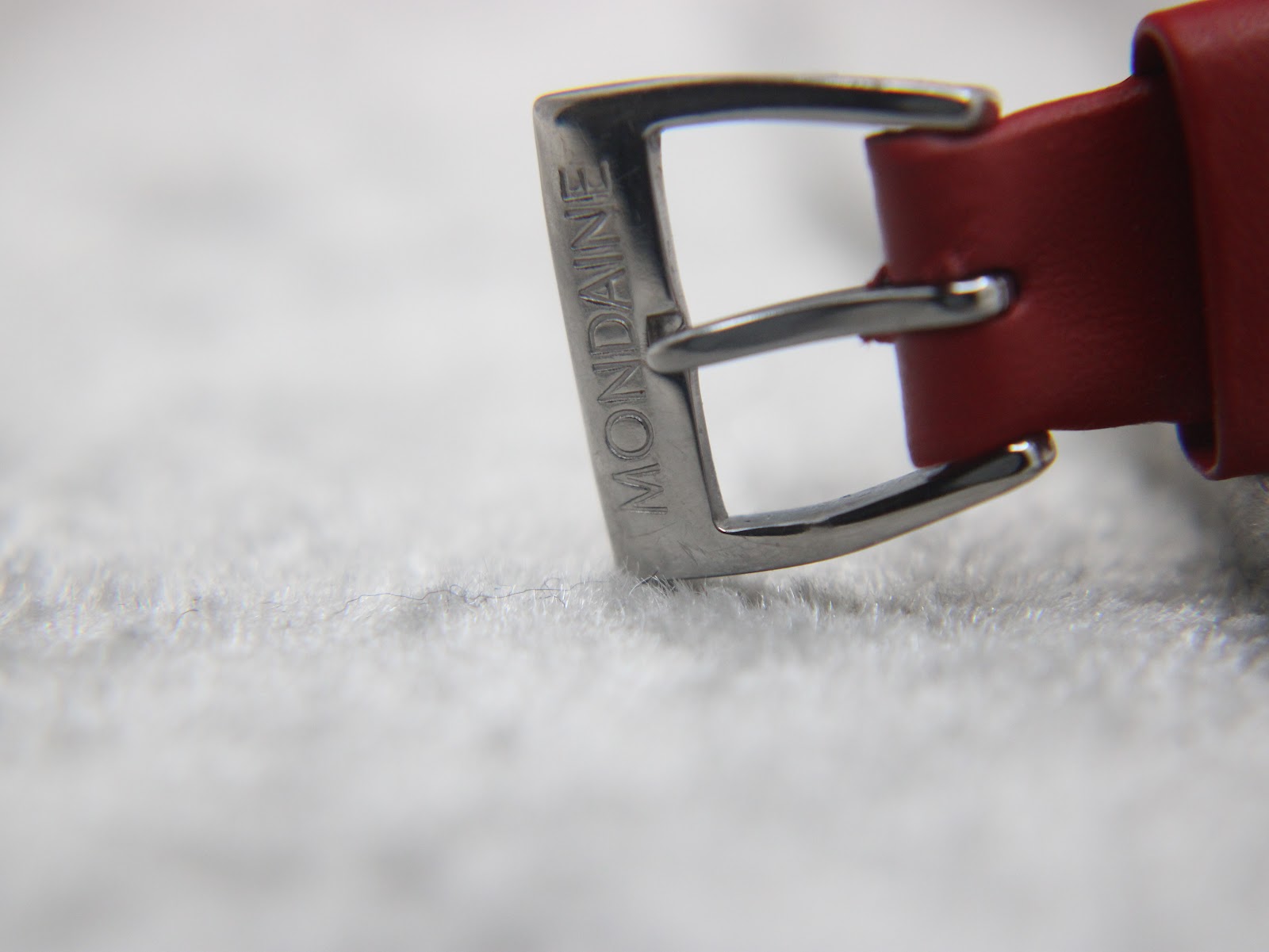 Detail shot of the polished stainless steel pin buckle, clearly engraved with the 'MONDAINE' brand name.