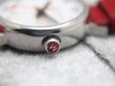 Close-up of the watch crown, featuring the iconic red Mondaine 'M' logo.