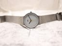 Full view of the Braun BN0211 watch laid flat, displaying the white dial, matte grey case, and the extended stainless steel mesh bracelet.