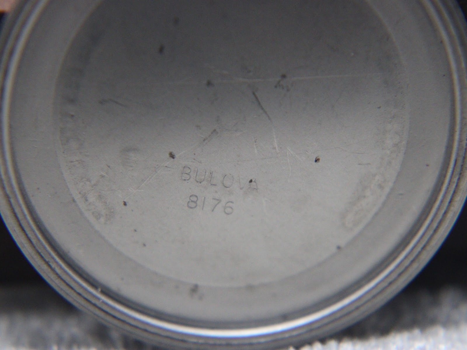 Close-up of an internal case back engraving 'BULOVA 8176'.