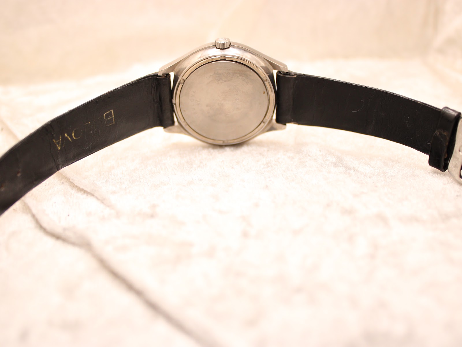 Full back view of the Bulova Accutron watch laid flat, showing the case back and strap.