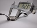 Digital caliper measuring the case diameter of the watch, showing a precise reading of 35.23 mm.
