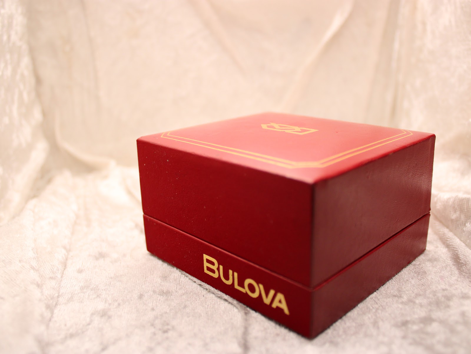 Closed original red Bulova presentation box with gold 'Bulova' branding on the front.