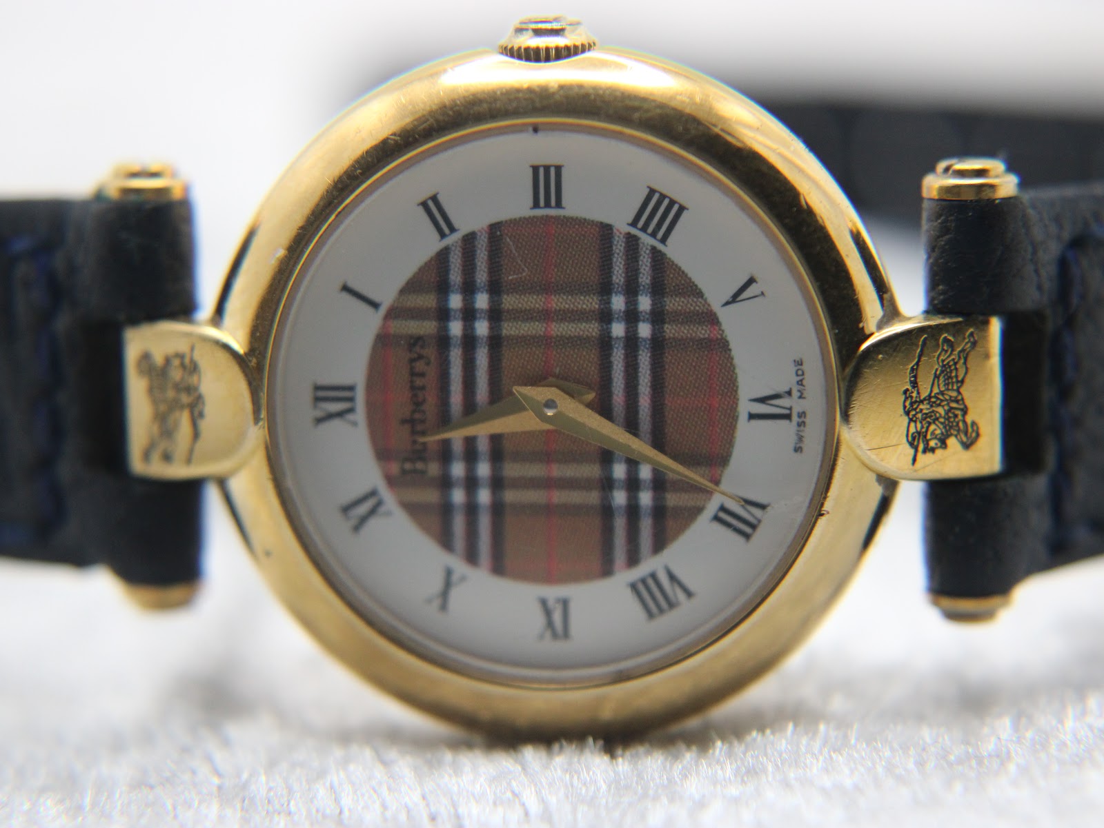 Detailed front view of the Burberrys check dial with Roman numerals and "Burberrys Swiss Made" text.
