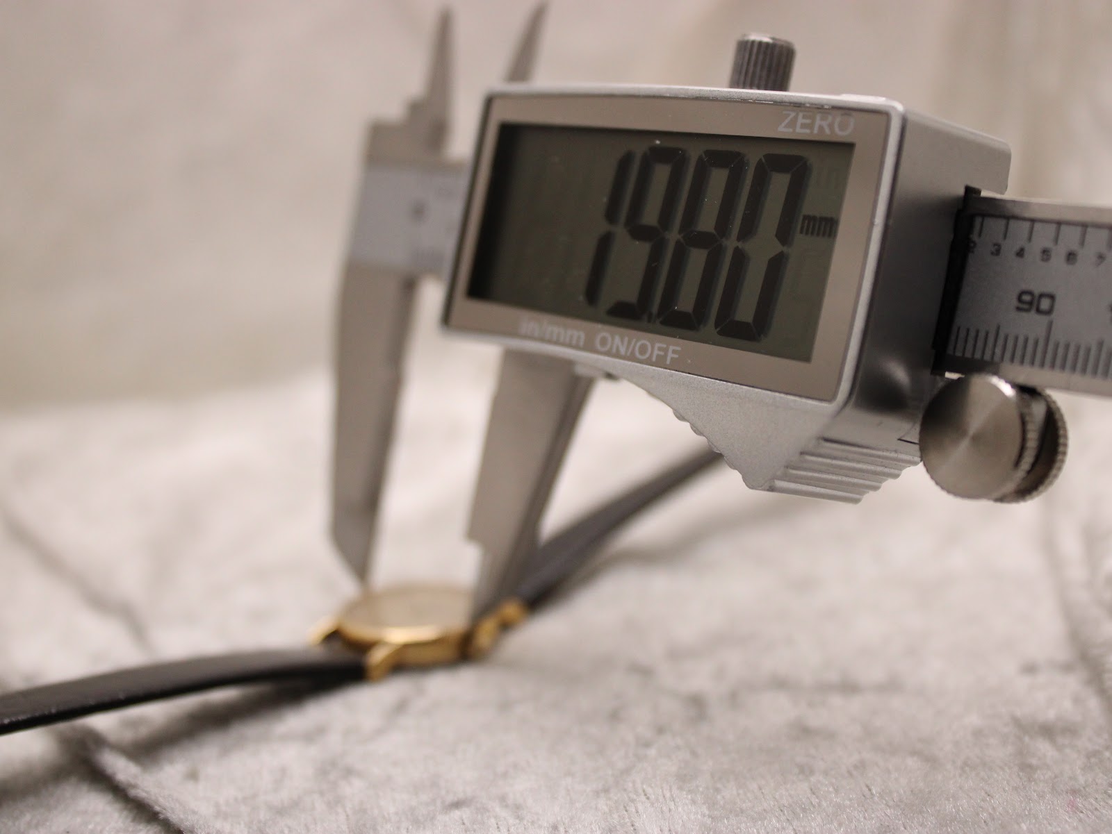 Digital caliper measuring the case diameter of the Longines Présence watch, showing an exact reading of "19.80 mm".