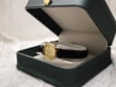 Angled view of the Longines Présence watch resting inside an open, dark green generic watch box.