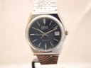 Front view of Oris Executive Crystal watch with navy dial, gold-tone bezel, and integrated steel bracelet.