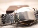 Close-up of the brushed stainless steel bracelet clasp, clearly showing the 'ORIS' brand signature.