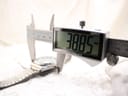 Digital caliper measuring the watch case width, displaying 38.85 mm.