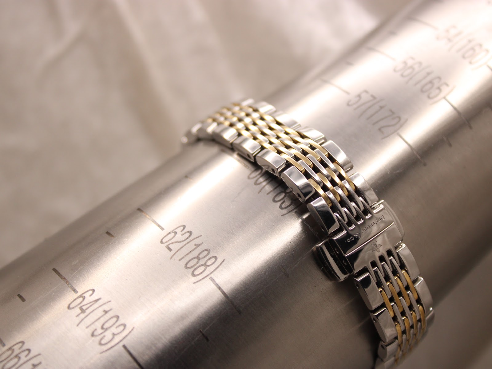 The two-tone stainless steel bracelet displayed on a watch sizing gauge, indicating a wrist circumference of approximately 18.8cm.