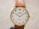 Front view of Roamer Canterbury dial with gold case, cream face, and black Arabic numerals. Light brown leather strap visible.