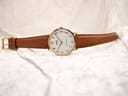 Full front view of the Roamer Canterbury watch with a light brown leather strap laid out on a white textured surface.