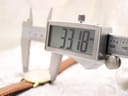 A digital caliper measuring the watch case diameter at 33.18mm, with the Roamer watch visible in the background.