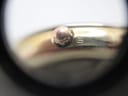 Macro shot of the gold-plated crown with a small marking on the side of the case.