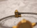 Close-up of the bracelet's clasp mechanism, showing the gold-tone metal and fastening screws.