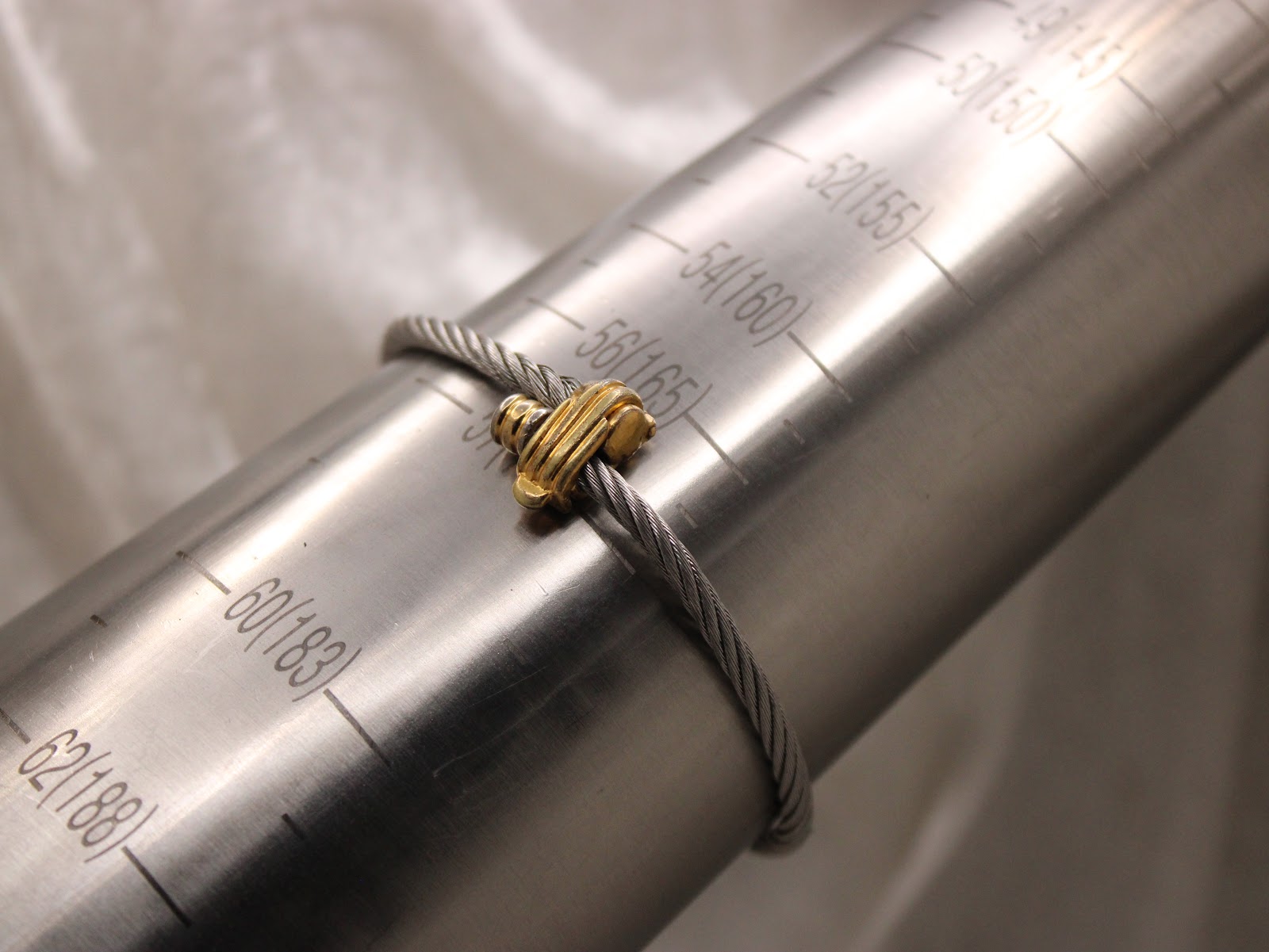 The watch bracelet wrapped around a metal ring sizer, showing a circumference measurement of approximately 160mm.