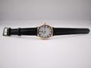 Overhead view of the Raymond Weil watch with its black leather strap fully extended on a white background.