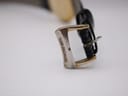 Close-up of the watch's gold-tone buckle, clearly showing the "RAYMOND WEIL" signature.