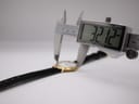 Digital caliper measuring the watch case, displaying a precise diameter of 32.12 mm.