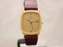 Front view of Zenith gold-plated rectangular watch with gold dial and burgundy leather strap.