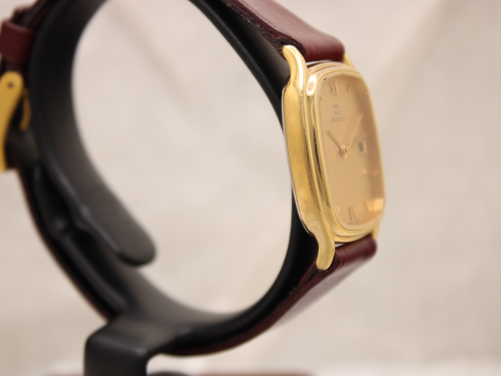 Angled side view of the Zenith watch on a black watch stand, highlighting the case shape.