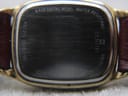 Close-up of the Zenith watch case back, showing scratches and 'base metal bezel water resistant stainless steel back' engravings.
