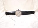 Frontal full view of the Omega De Ville automatic watch on its black leather strap, presented against a soft white background.