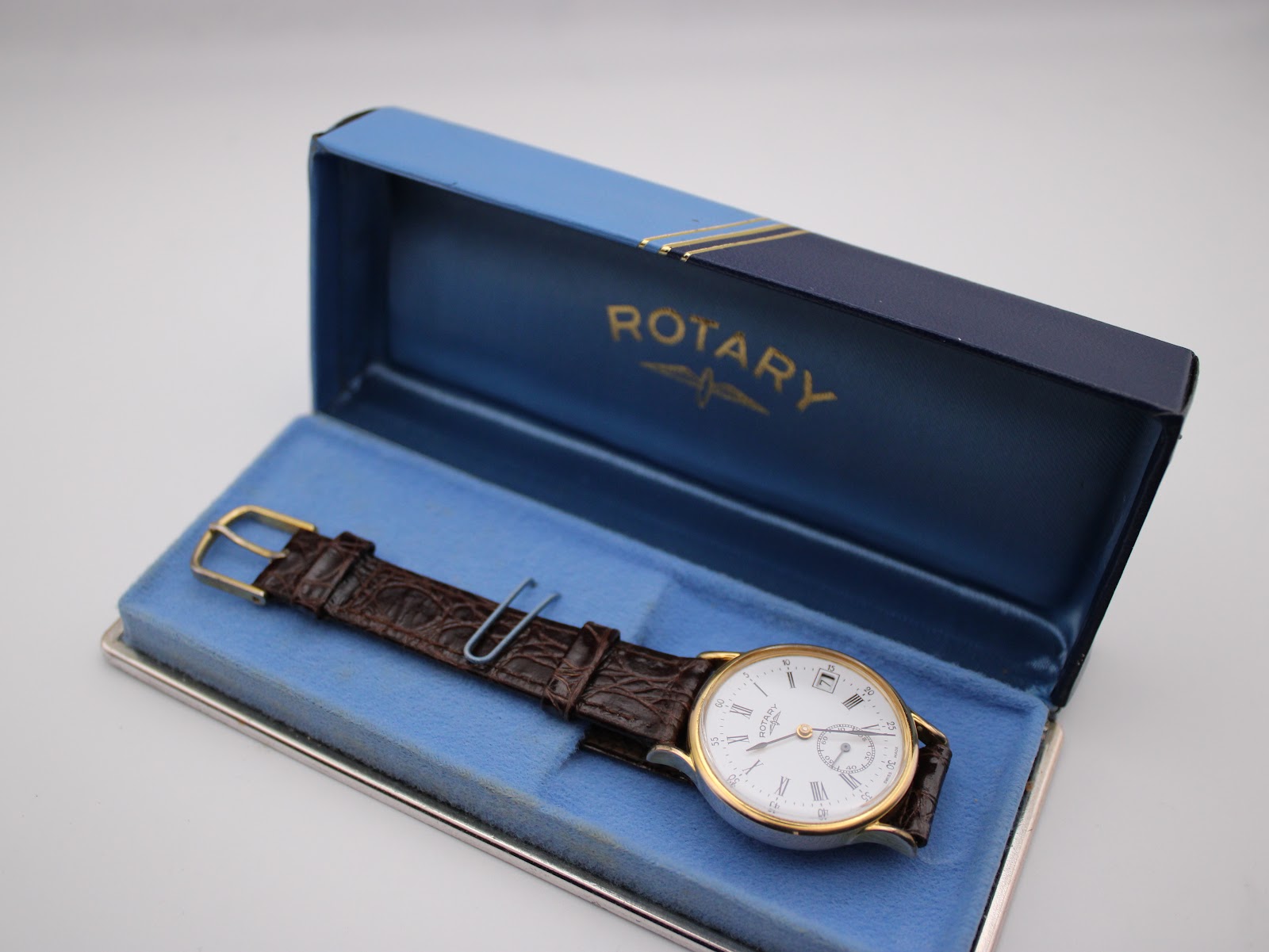 The Rotary watch nestled inside an open vintage blue and gold Rotary presentation box, showing the inner blue lining.