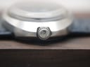 Detailed close-up of the original signed Omega crown on the side of the watch case, showing the Omega symbol.