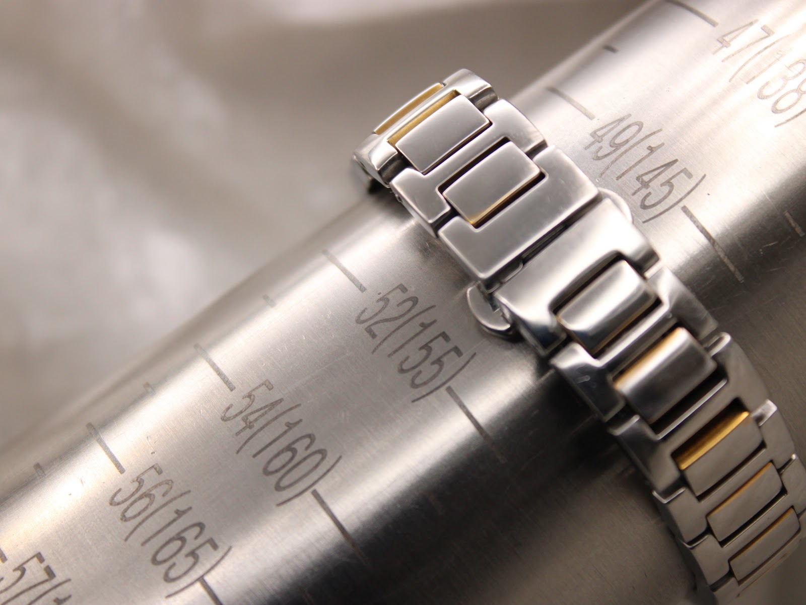 The Gucci bracelet wrapped around a watch sizing cone, indicating a wrist circumference measurement of 155mm.