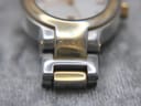 Close-up of the bracelet attachment to the case, displaying the "Gucci Timepieces" engraving on the gold-tone link.